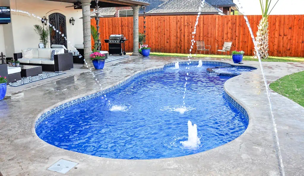 Custom swimming pool with deck jets and LED pool lighting.