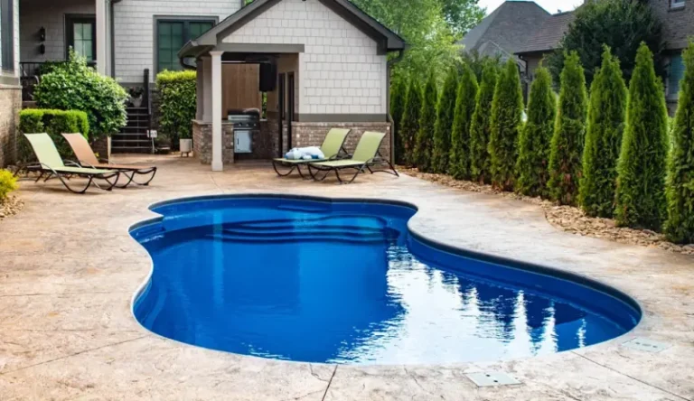 Crystal-clear fiberglass pool with steps leading into the shallow end.