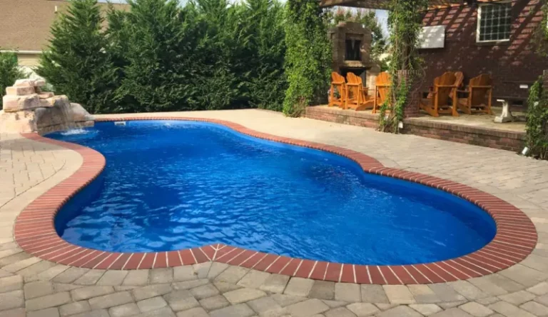 A serene backyard pool with water features and stone coping.