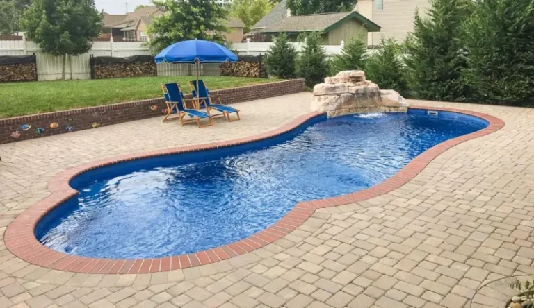 Custom inground pool with waterfall feature and natural stone surround.
