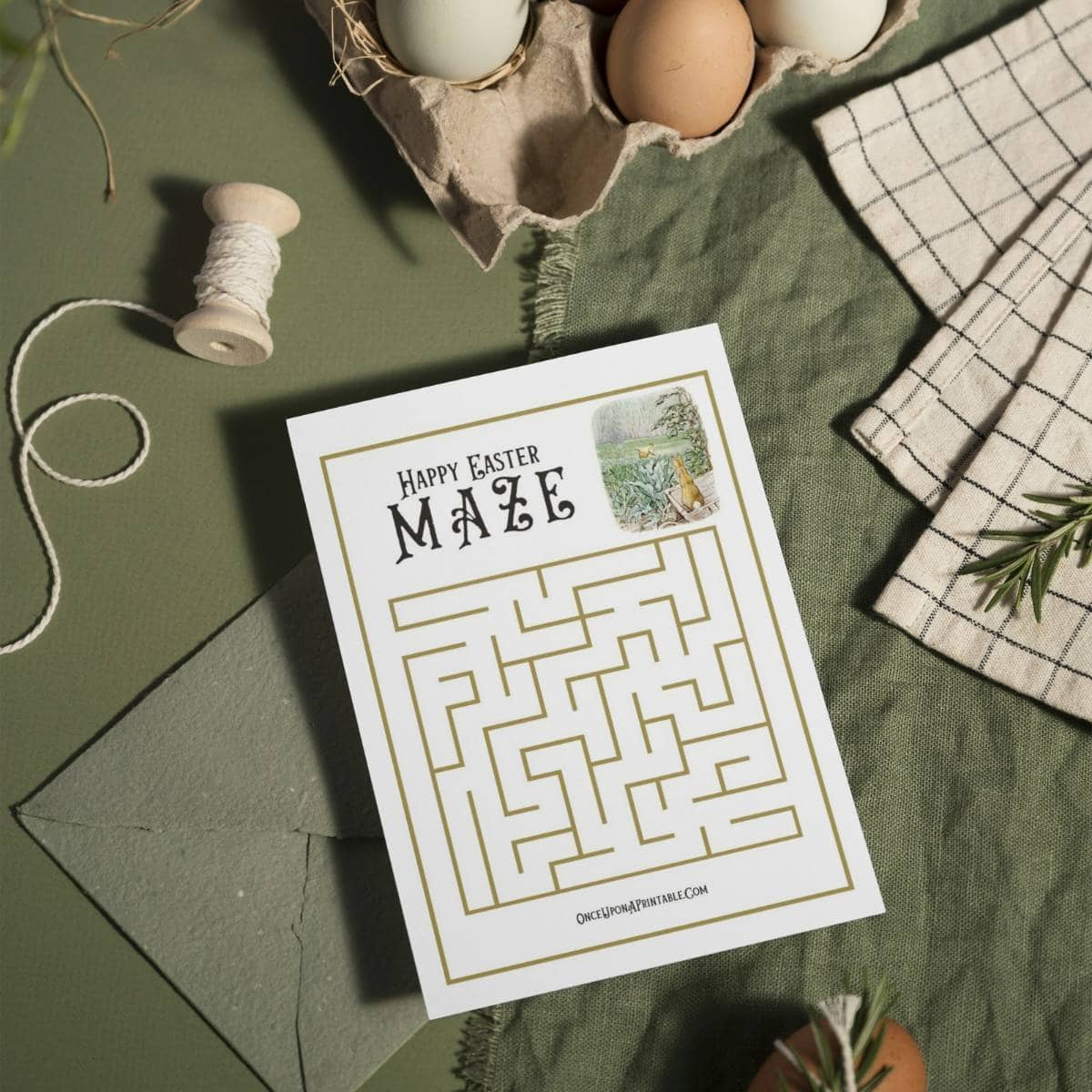 Fun and easy Easter mazes for kids with Peter Rabbit illustrations, sitting on a green table cloth with wooden eggs and string.