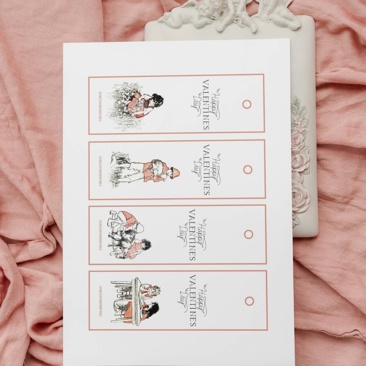 Vintage illustrated Heidi Valentine's Day bookmarks on a pink blanket.