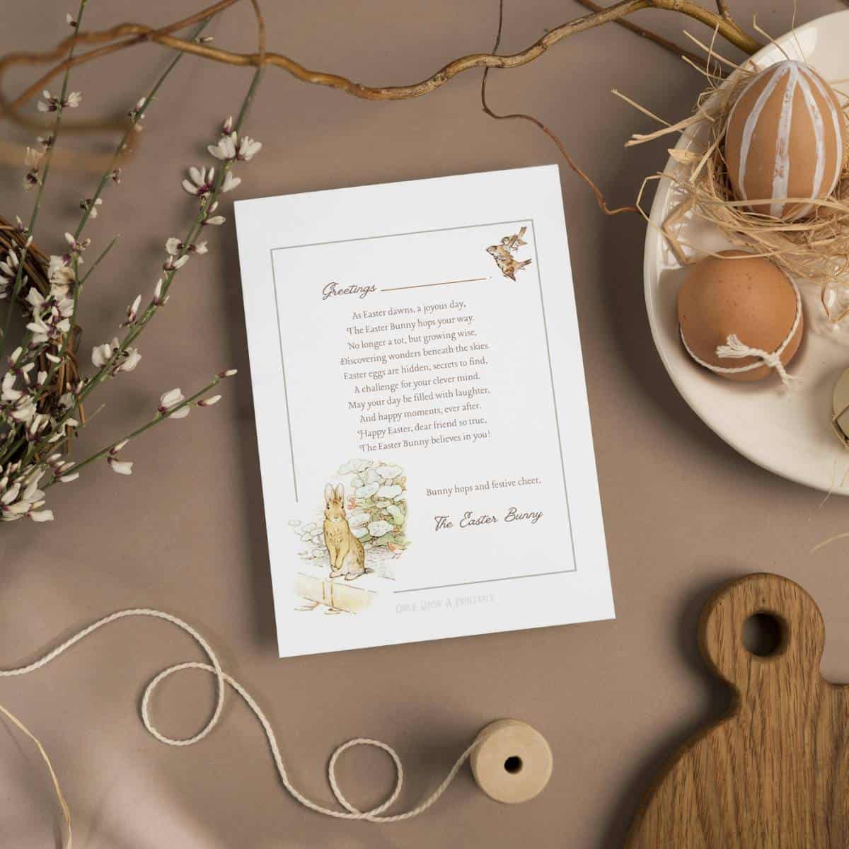 Peter Rabbit Easter bunny letter on a brown table cloth with brown eggs and flowers.