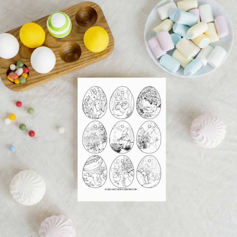 Peter rabbit and friends coloring ornaments laying on a table with eggs and candy.