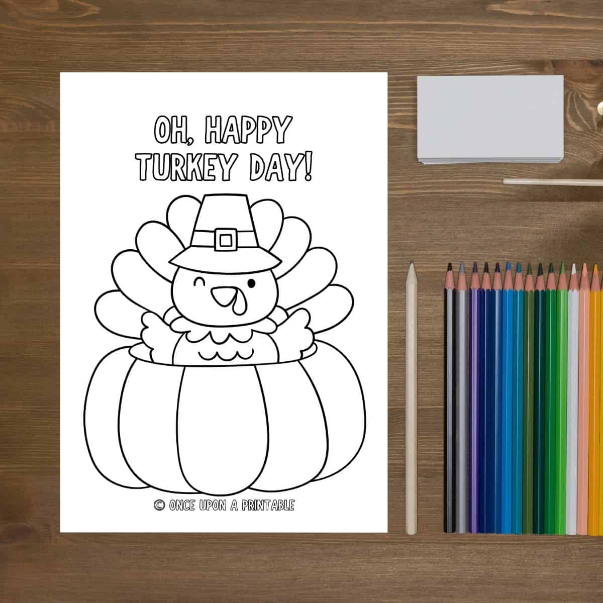 Simple thanksgiving coloring page with a turkey in a pumpkin next to coloring pencils.
