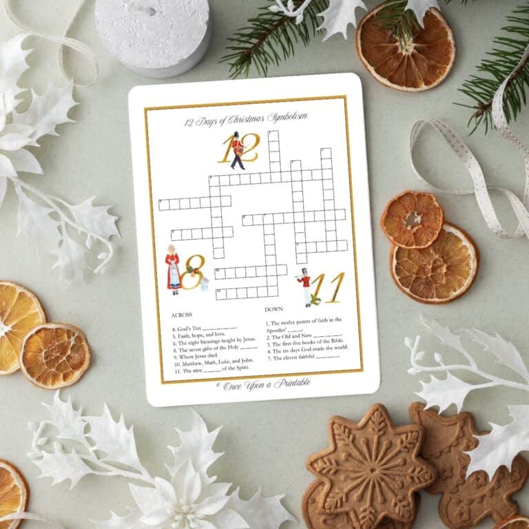 12 Days of Christmas illustrated crossword puzzle laying on a table with garland, dried oranges, and paper snowflakes.