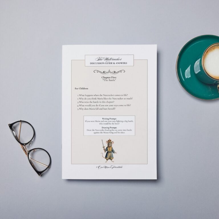 The Nutcracker read-aloud companion page laying on a table with glasses and a cup.