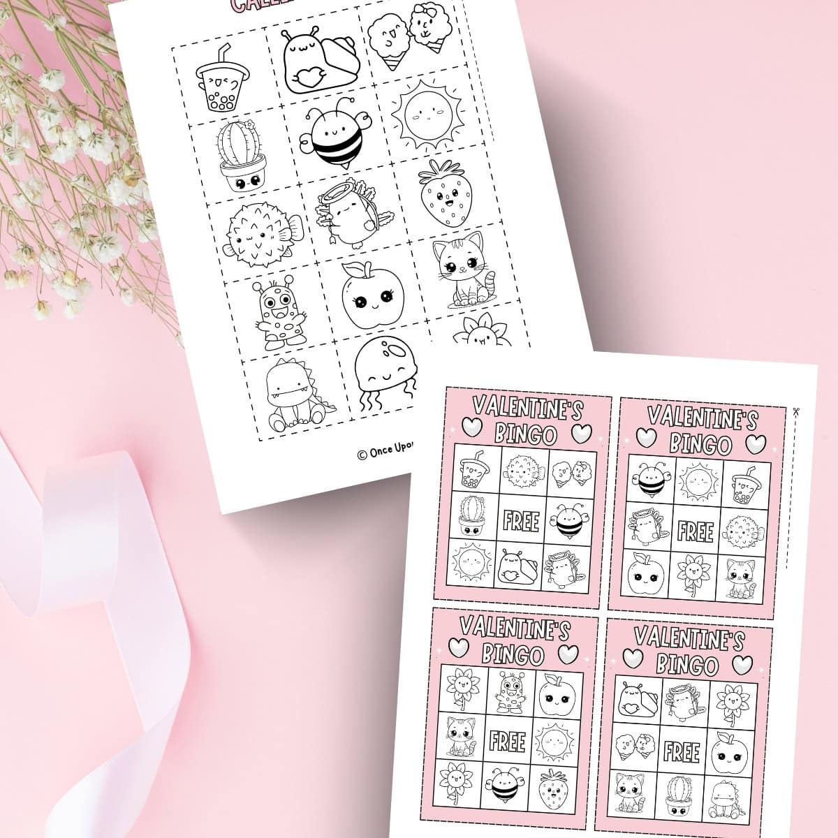 Valentine's day coloring bingo cards with coloring calling cards laying on a pink background with baby's breath flowers.