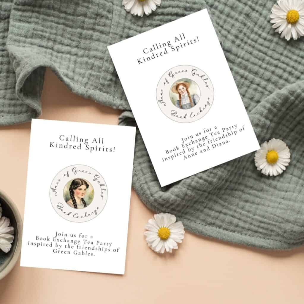 Anne and Diana book exchange invitations laying on a green blanket with daisies.