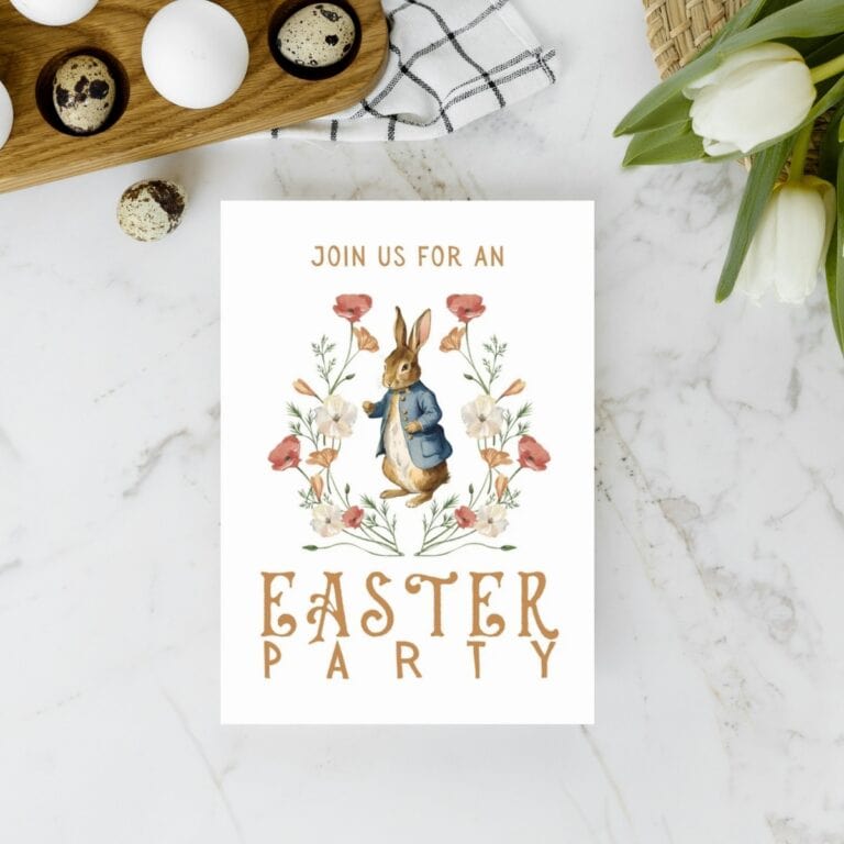 Peter Rabbit inspired Easter party invite card laying on a marble countertop with tulips, eggs, and a kitchen towel.