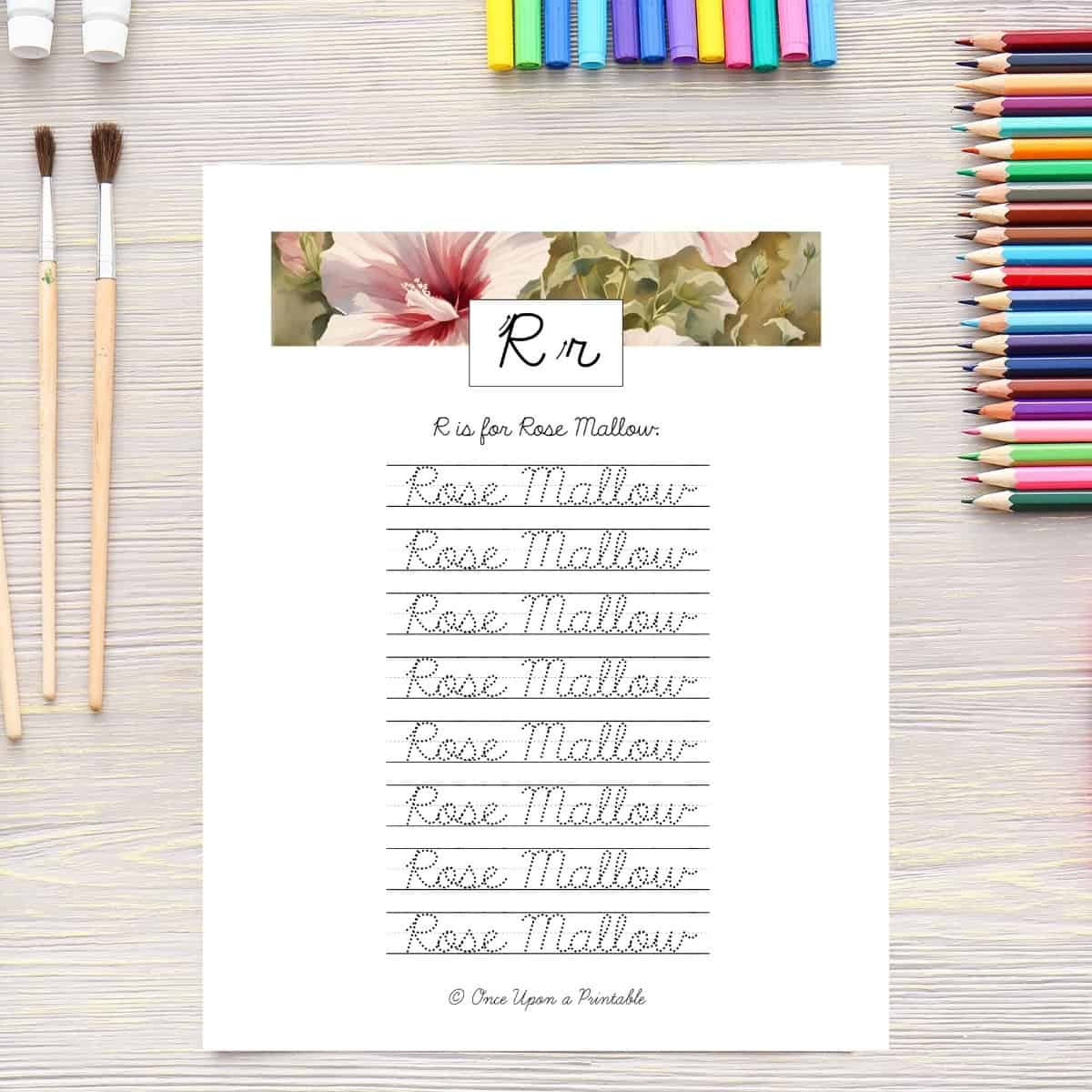 Wildflower cursive practice worksheet laying on a table with coloring pencils.