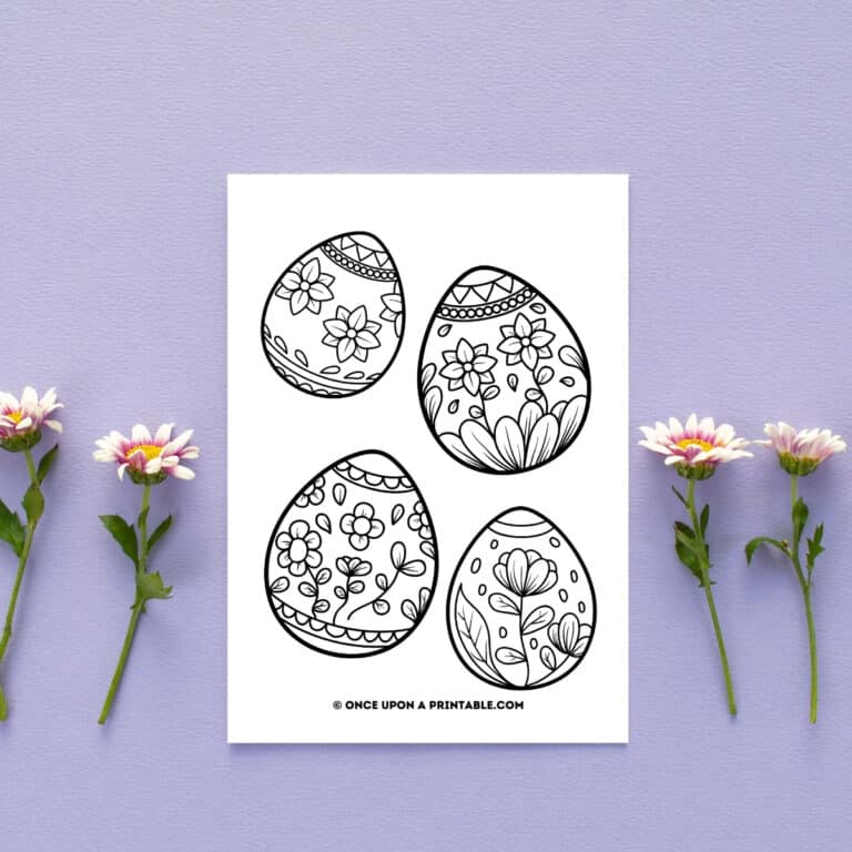 Free printable Easter coloring pages round up post, a coloring page with four beautiful easter eggs for coloring sitting by daisies.