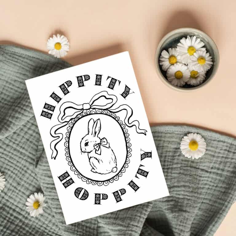 Happy Easter coloring card with a bunny rabbit with a bow laying on a green blanket with daisies.