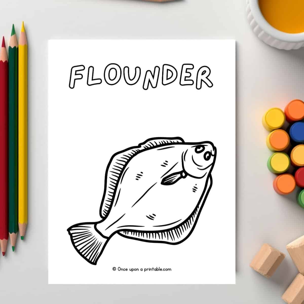 F is for Flounder animal coloring pages laying on a white table with paints and coloring pencils.