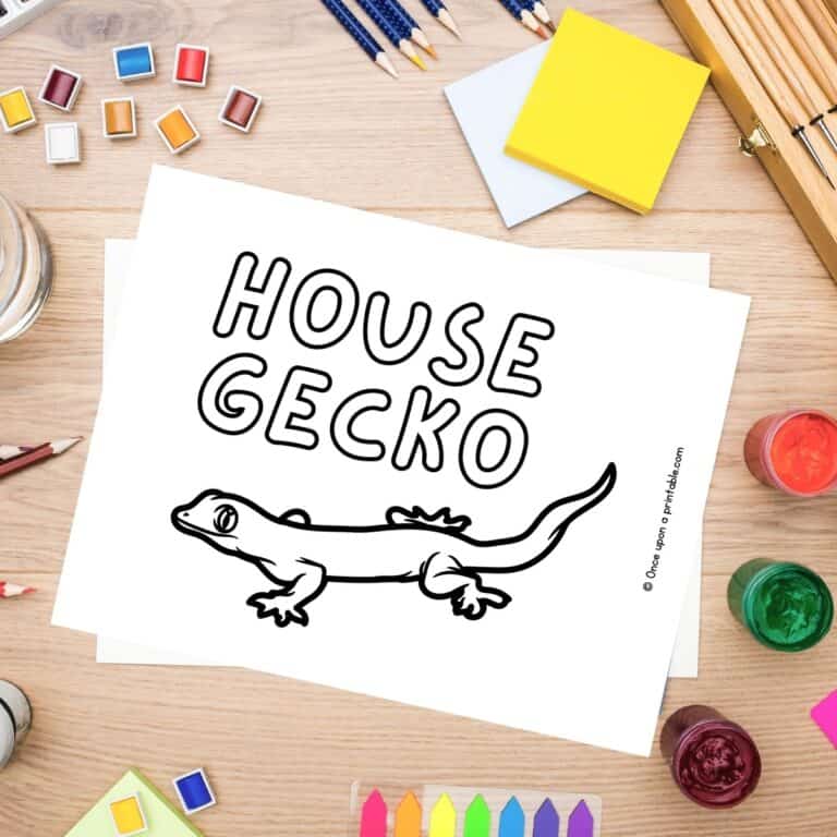 H is for House Gecko coloring page laying on a table with coloring supplies like crayons, pencils, and paint.
