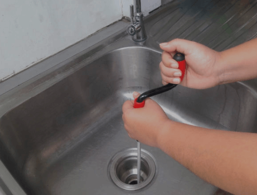 Technician performing residential drain cleaning service