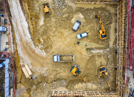 Excavators clearing land for new commercial construction project