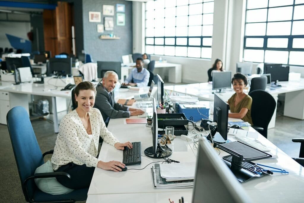 Equipo multigeneracional trabajando en una oficina abierta, representando colaboración, diversidad y la integración del talento senior en el entorno laboral.