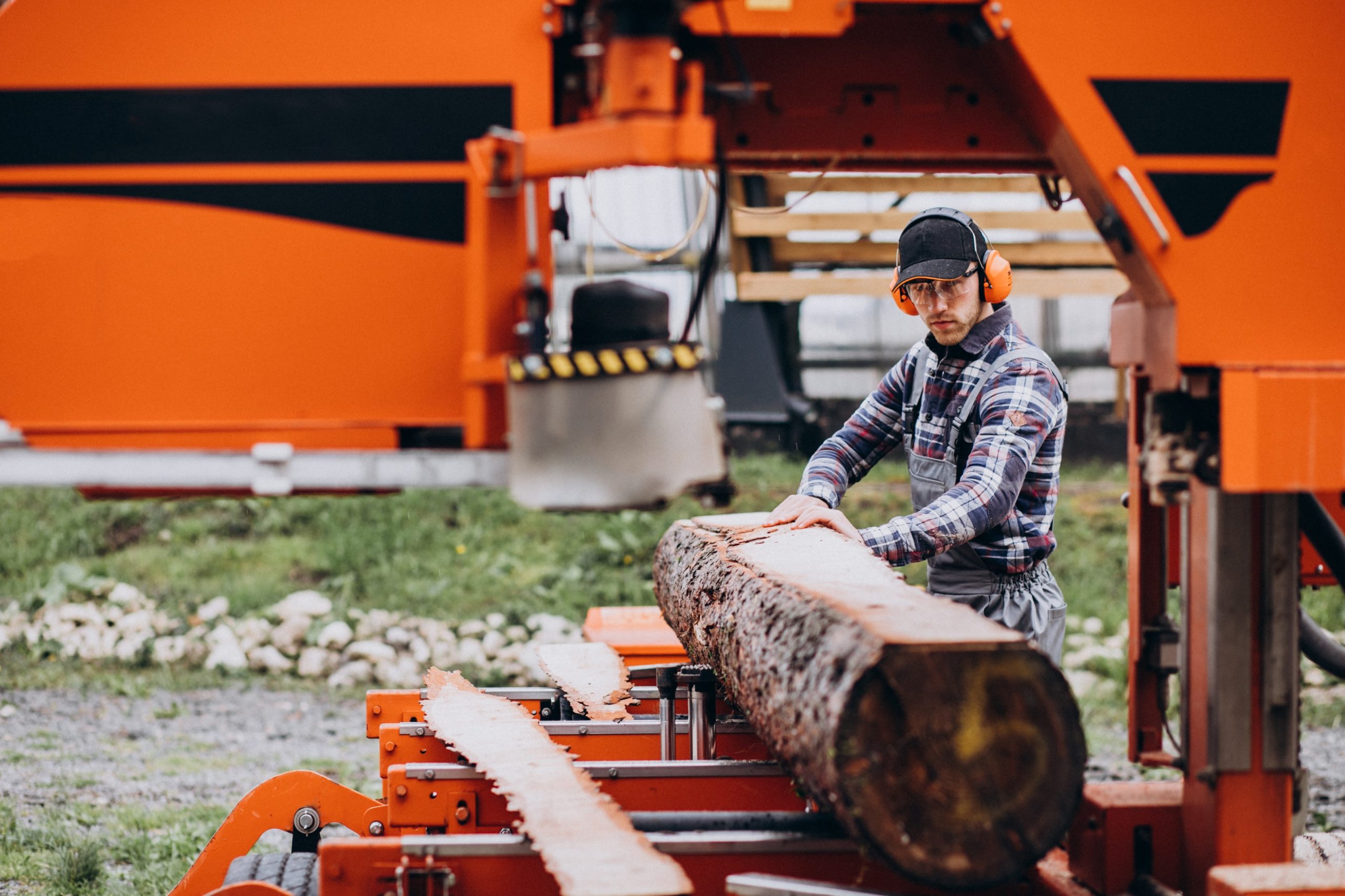 At Roubic Tree Service LLC, we prioritize both safety and precision in every task, embodying professionalism from start to finish. Our expertly trained team members, equipped with top-tier protective gear, ensure precise cuts using state-of-the-art industrial sawmills. One of our dedicated professionals—dressed in a classic plaid shirt and cap for comfort and style—carefully operates the machinery while wearing essential orange ear protectors to maintain a sharp focus on every intricate detail of the job. At Roubic Tree Service LLC, cutting large logs is not just a task; its a commitment to quality craftsmanship that delivers exceptional results every time. Discover our expert tree services today at https://roubictreeservice.com/.