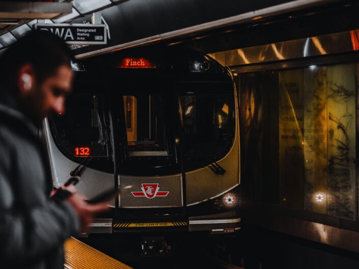 A shot of a man standing on the subway platform as the train approaches.