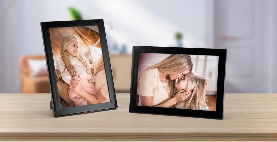Framed family photographs on wooden table.