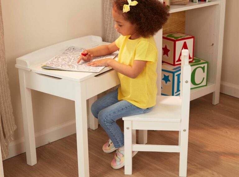 Child coloring at small white desk