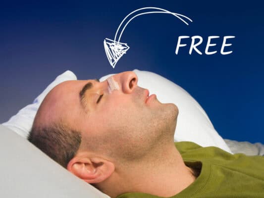 Man sleeping with nasal strip, blue background.
