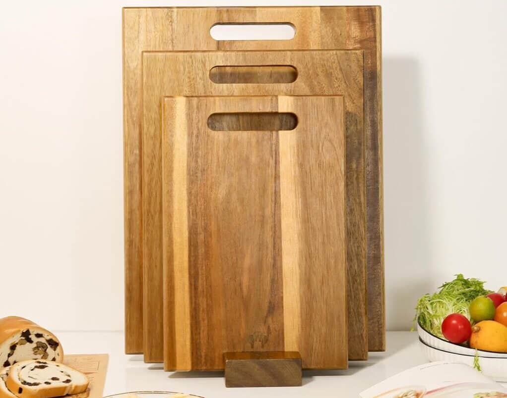 Three stacked wooden cutting boards in kitchen scene.