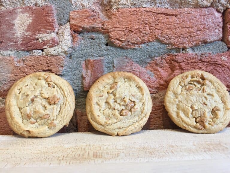 Three cookies against a brick wall backdrop.