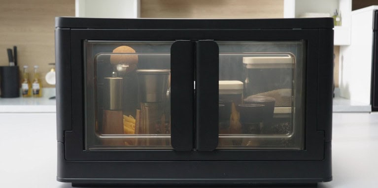 Black kitchen appliance storing bottles and containers.