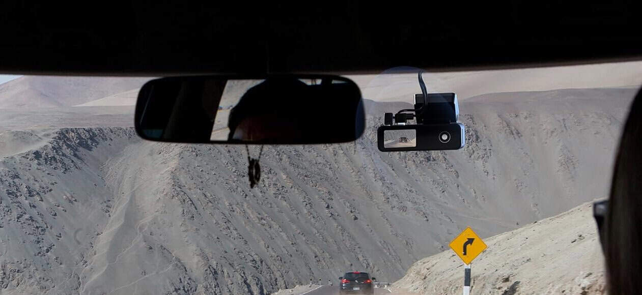 Driving on mountain road with dashcam view ahead.