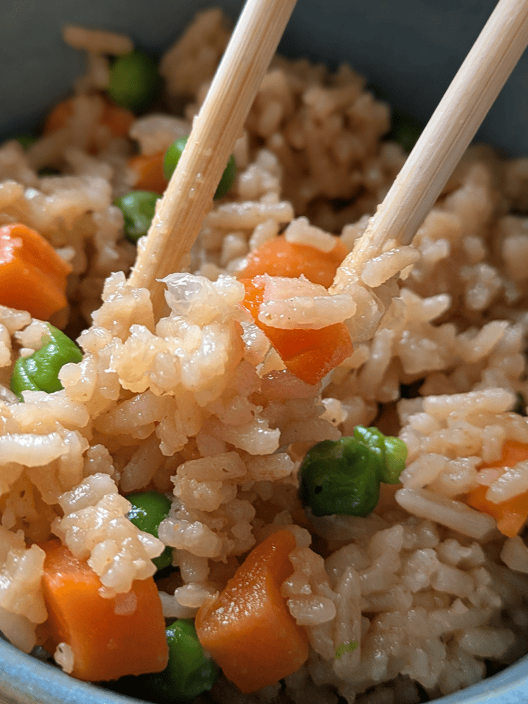 A bowl of steaming hot gluten-free vegan Instant Pot fried rice with colorful vegetables.