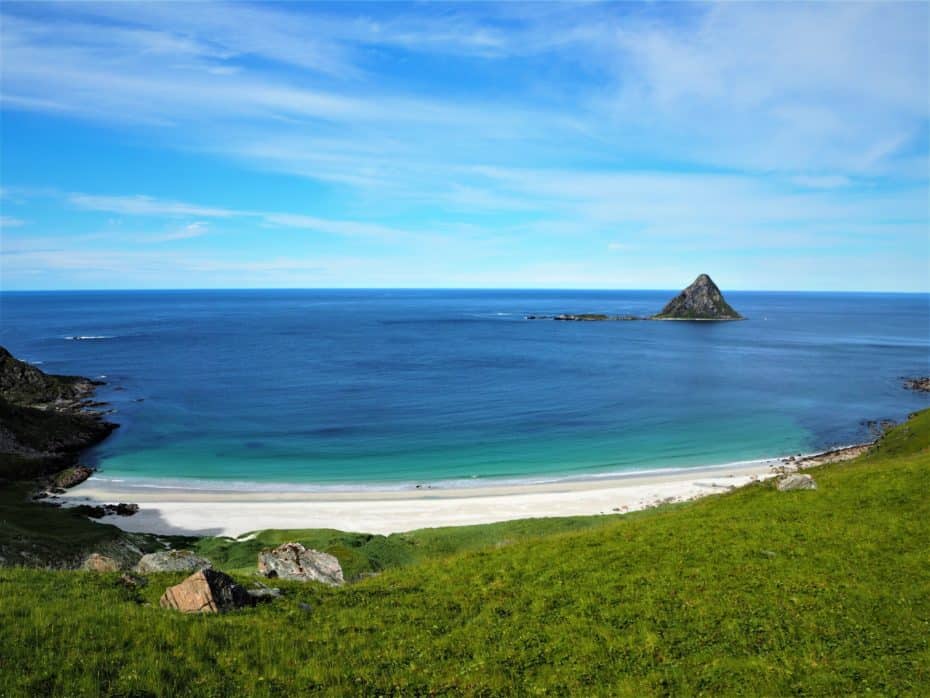 Plage déserte avec vue sur l'océan et une petite île sombre, Lofoten