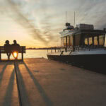 Two people watching the sunset waiting to board a water taxi