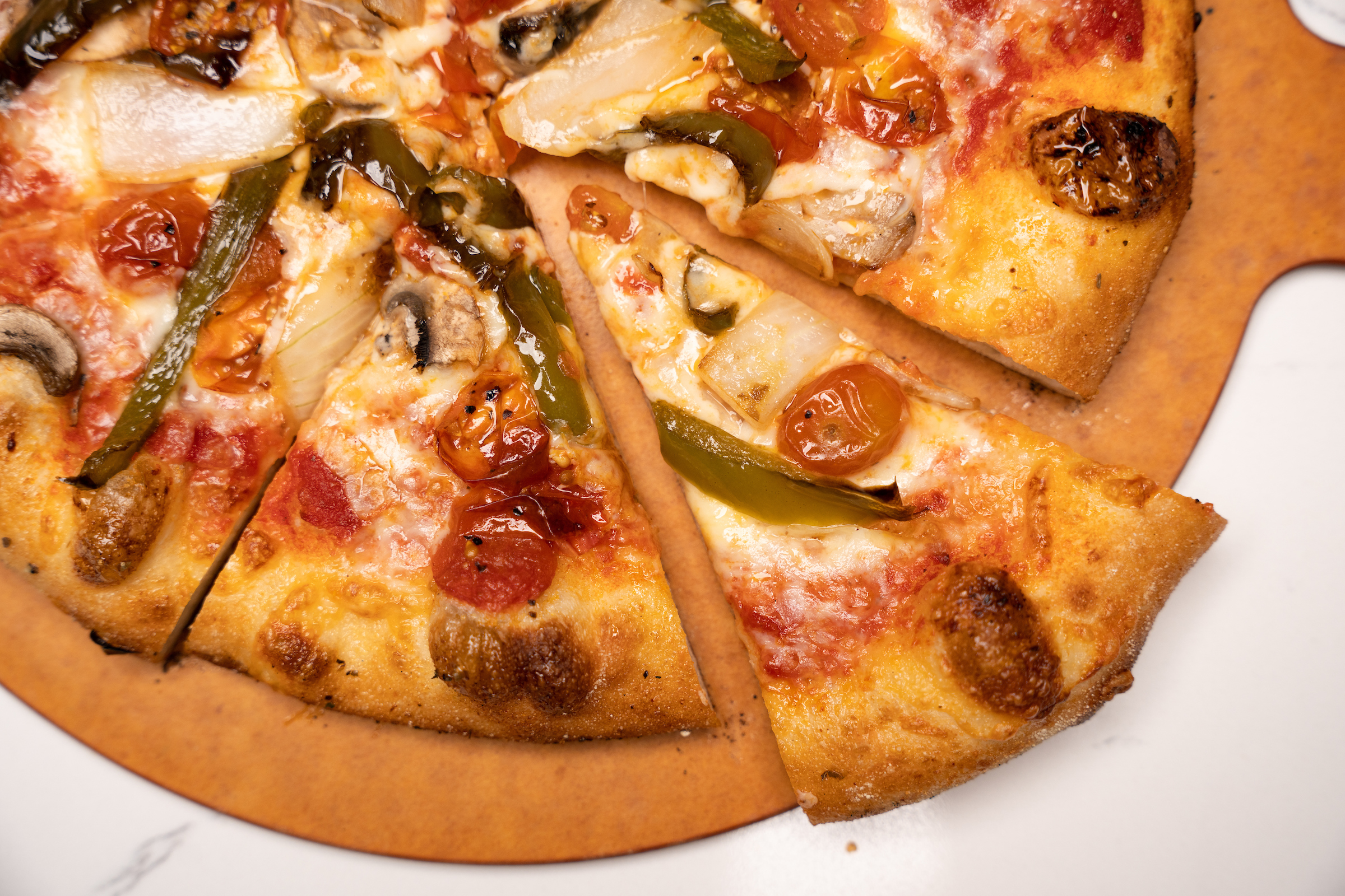 A pizza with tomato, peppers, and onion