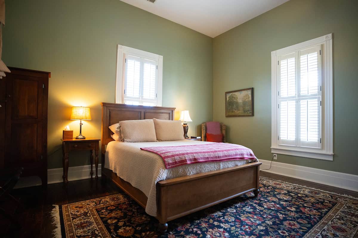The house is made up of a two-story log cabin that was once part of a school that is rumored to have taught a Kentucky governor. A Victorian addition was built in the late 1800s and gives the two downstairs bedrooms tall ceilings and light. The third bedroom is in the loft of the cabin and accessed by a ladder. There is a king bed and a queen bed on the main floor and a full-size bed in the loft. The living area has a wood-burning stove and a queen sleeper sofa.