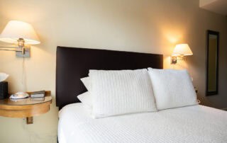 We offer eight guest rooms with queen beds and small ensuite baths. Some amenities include luxury bedding, flat-screen televisions, high-speed wireless internet, blackout shades, and our handcrafted Plainview Farm toiletries. We also provide filtered water and Nespresso makers in the kitchenette near the rooms and a small sitting area for reading or working. The kitchenette has a microwave, refrigerator drawer, and freezer drawer for use by guests. Nearby is a washer and dryer, also available for guest use.