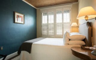 We offer eight guest rooms with queen beds and small ensuite baths. Some amenities include luxury bedding, flat-screen televisions, high-speed wireless internet, blackout shades, and our handcrafted Plainview Farm toiletries. We also provide filtered water and Nespresso makers in the kitchenette near the rooms and a small sitting area for reading or working. The kitchenette has a microwave, refrigerator drawer, and freezer drawer for use by guests. Nearby is a washer and dryer, also available for guest use.