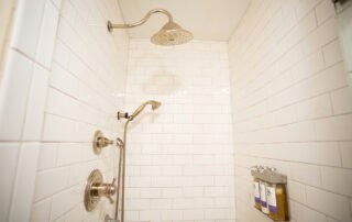 We offer eight guest rooms with queen beds and small ensuite baths. Some amenities include luxury bedding, flat-screen televisions, high-speed wireless internet, blackout shades, and our handcrafted Plainview Farm toiletries. We also provide filtered water and Nespresso makers in the kitchenette near the rooms and a small sitting area for reading or working. The kitchenette has a microwave, refrigerator drawer, and freezer drawer for use by guests. Nearby is a washer and dryer, also available for guest use. There is a king bed and a queen bed on the main floor and a full-size bed in the loft. The living area has a wood-burning stove and a queen sleeper sofa.