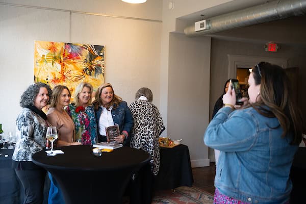Group of women smiling during a meet and greet author event for the launch of Angela Correll's Restore in Tuscany