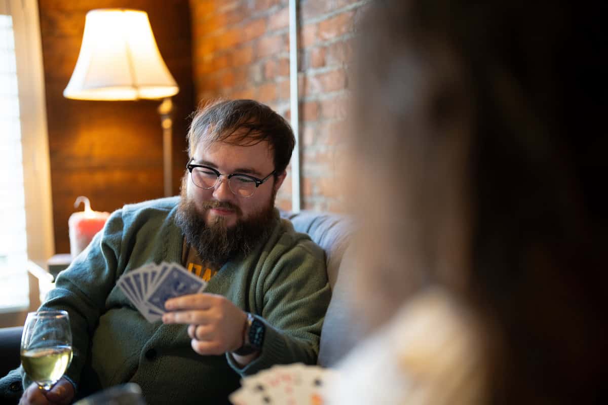 Two people drinking wine and playing cards