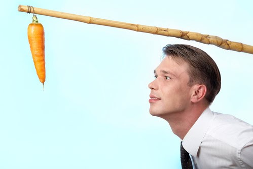 Portrait of businessman looking at fresh carrot on angle