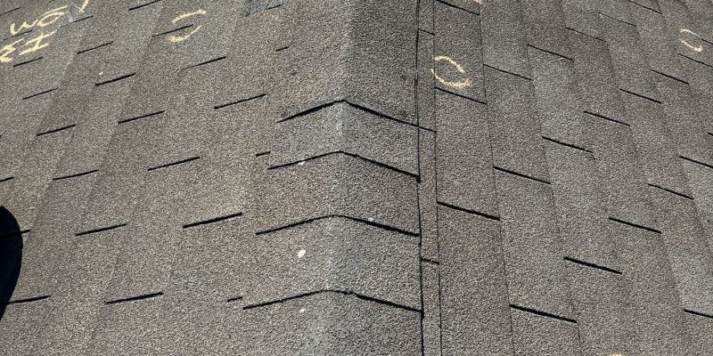 Damaged roof shingles with visible weather impact after recent storm
