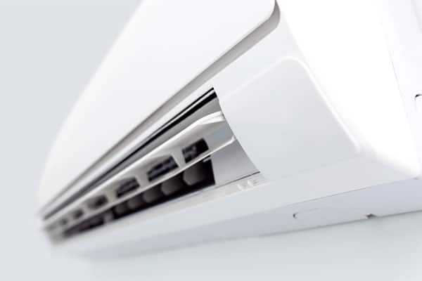 Close-up view of a white wall-mounted air conditioning unit with visible vents.