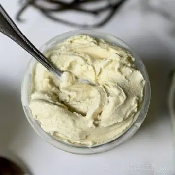 vanilla ice cream in a ninja creami pint container, with a spoon.