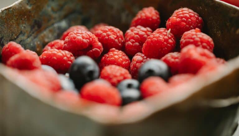 Fresh mix of raspberries and blueberries in a wooden bowl