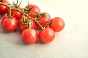 Fresh cherry tomatoes on the vine, showcasing healthy plant-based foods for lowering blood pressure with diet.