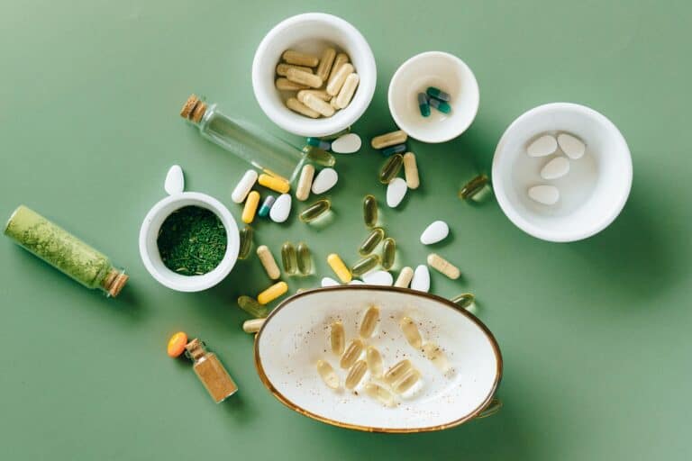 A variety of supplements, including capsules, pills, and powders, displayed on a green background. Learn how to identify safe supplements and understand supplement regulation in Europe and the U.S.
