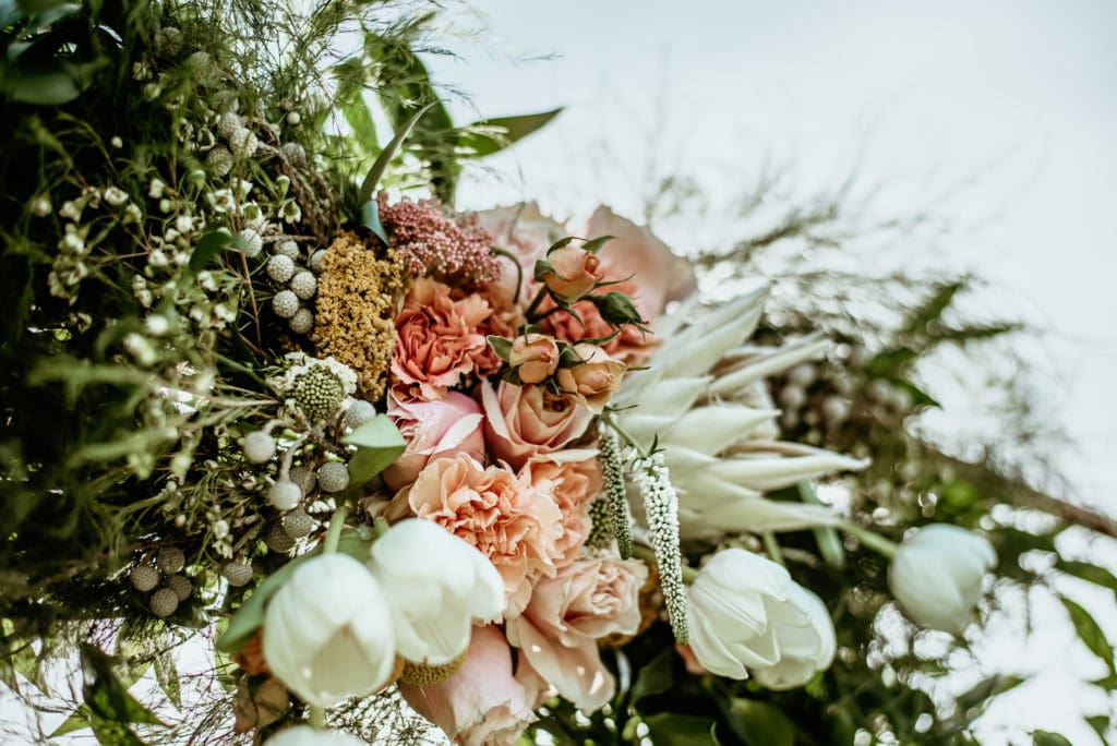Incredible spring florals with white tulips, pink roses, and an assortment of unique florals for garden wedding at Agritopia Farms