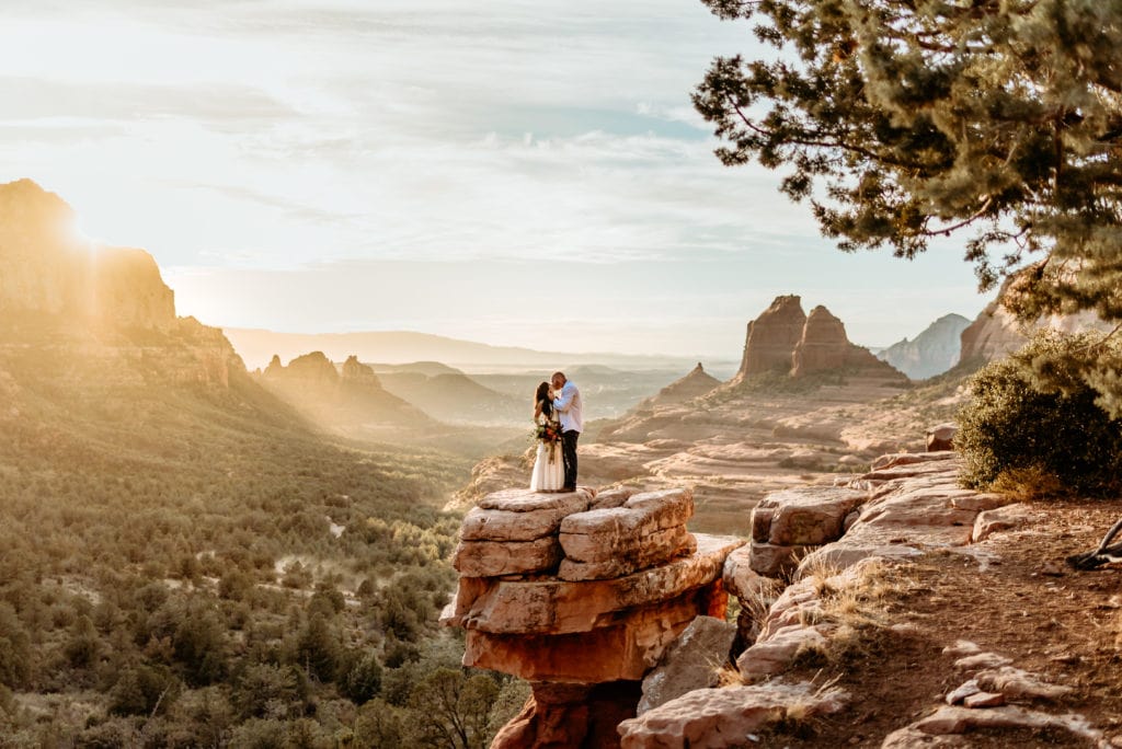 Couple embracing on Merry Go Round Rock overlook during their Sedona, Arizona elopement